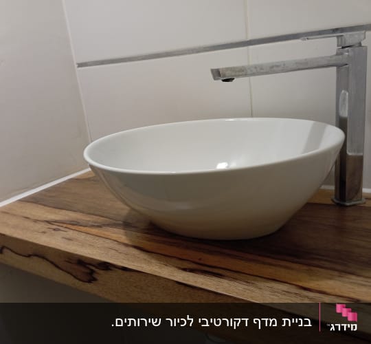כיור עגול על מדף עץ עם ברז מתכת